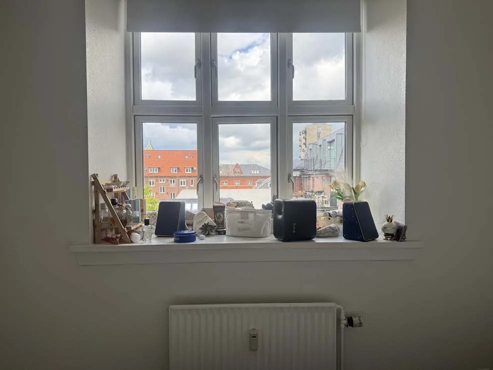 Projector and speakers on a windowsill in a user's home