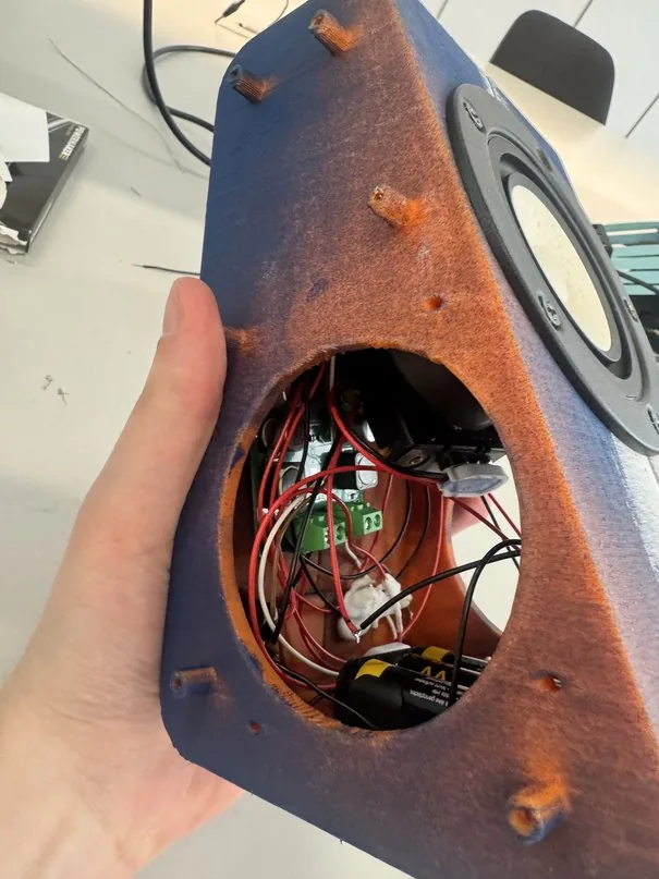Hand holding the open cabinet, wiring and driver visible inside