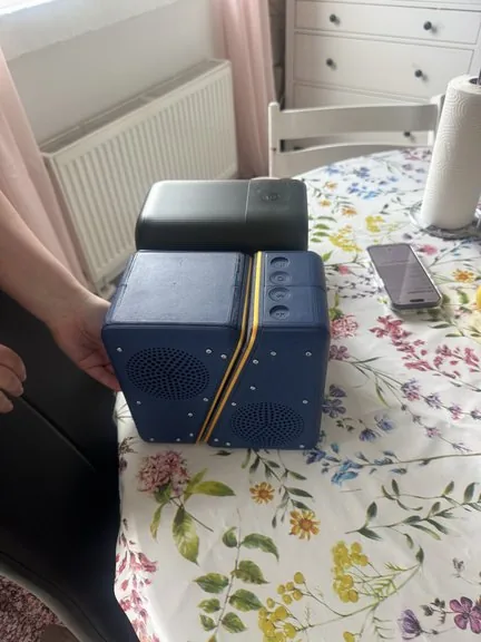 User carrying a speaker by its handle recess