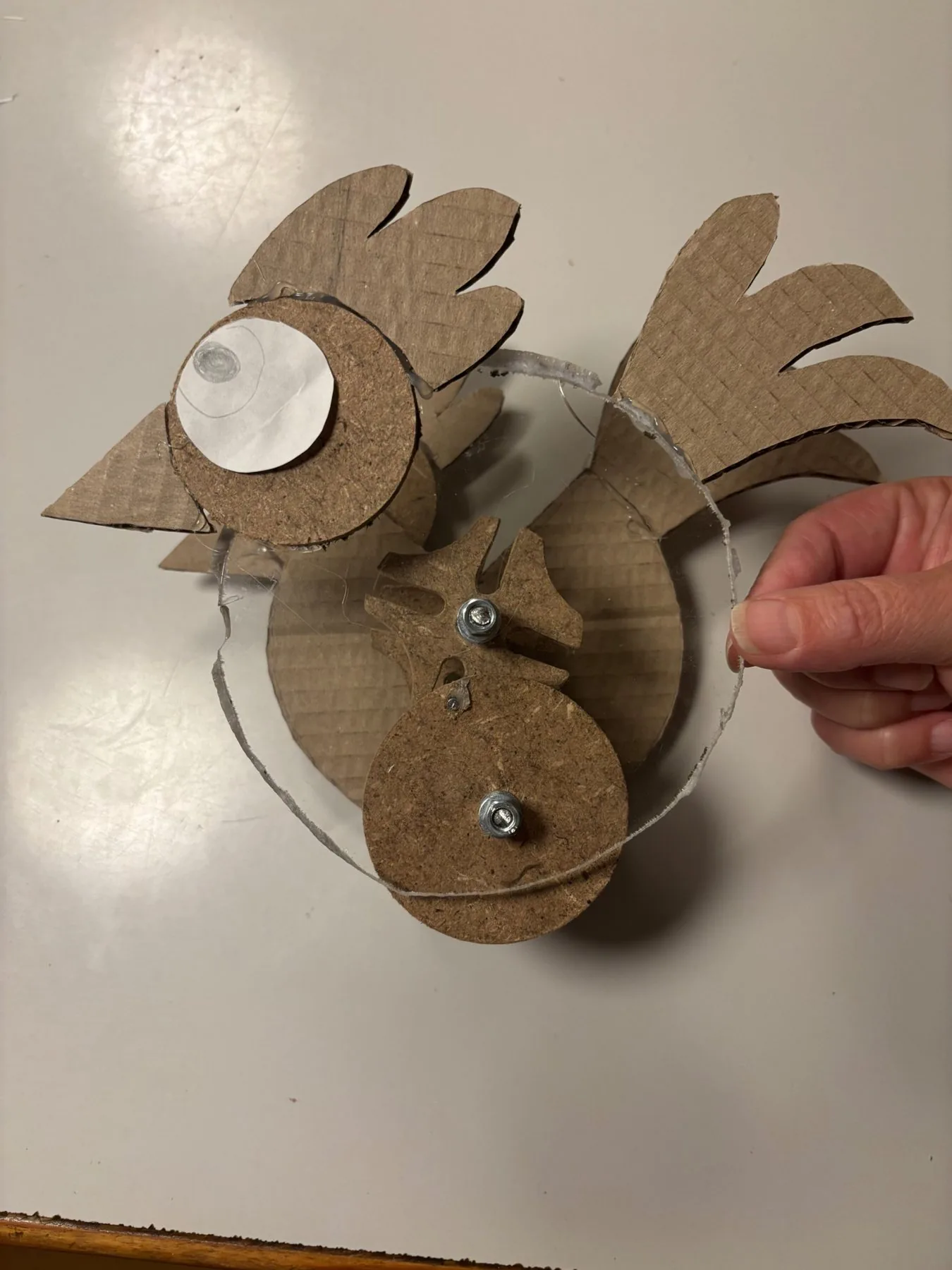 Top view of the prototype held by a hand: plexi shell, wooden star wheel and drive disc bolted together