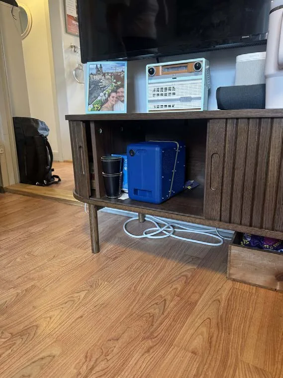 Speaker on the shelf of a TV bench in a user's living room